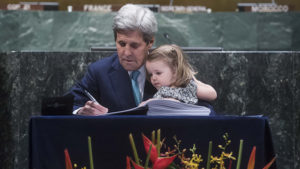 ohn Kerry signs the Paris Agreement With granddaughter Isabelle on his lap in April 2016 (Pic: UN Photos/Amanda Voisard)